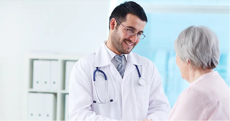 Aa doctor smiling and talking to an old lady.