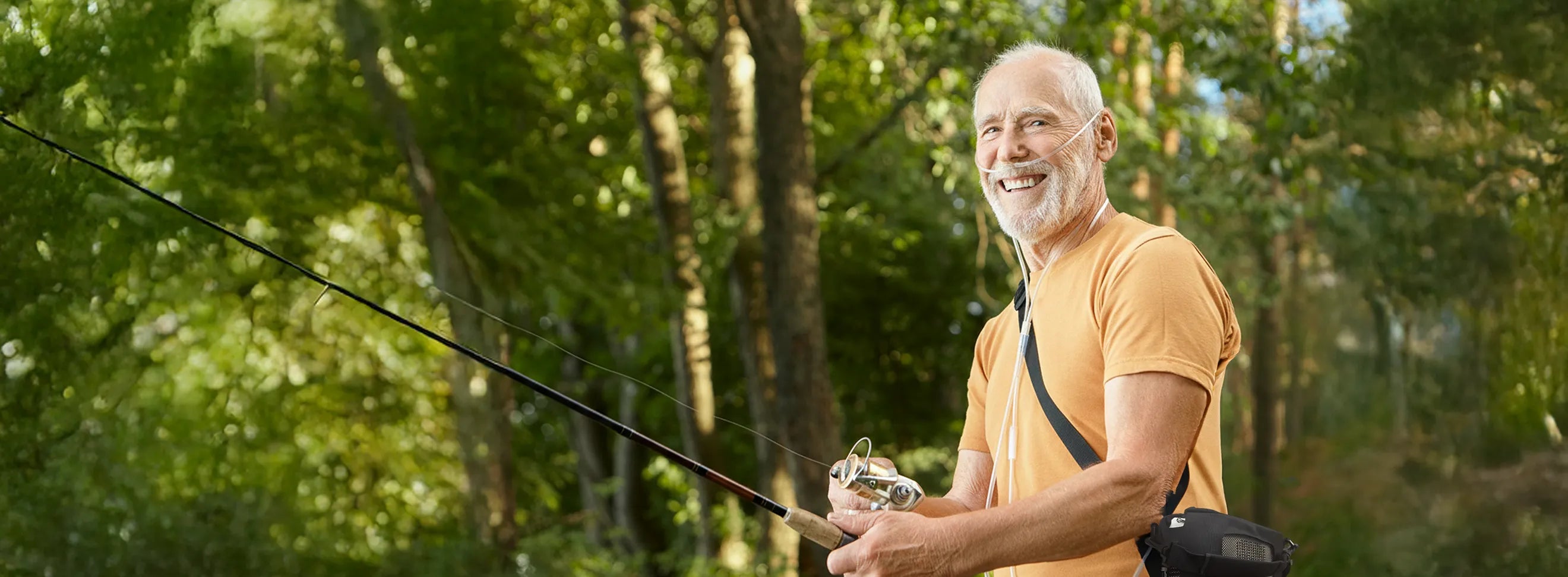 Man smiling and fishing while using a Kingon P2 portable oxygen concentrator.
