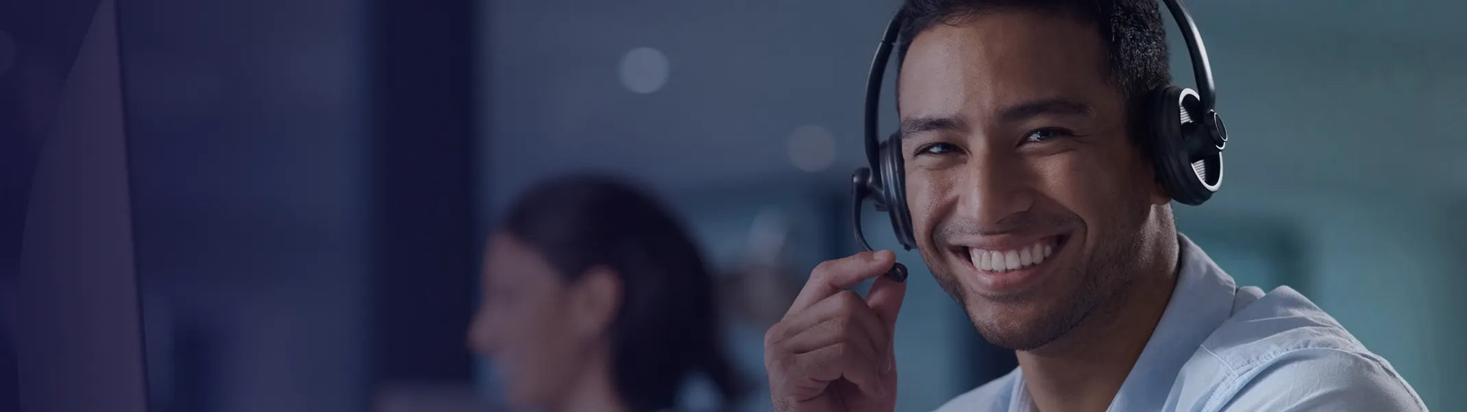 A service agent with a headset on smiling.